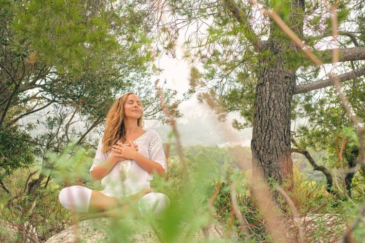 Sumérgete en la calma y la serenidad de la naturaleza mientras una mujer sonríe radiante, sentada en medio de un exuberante bosque. Un rayo de luz dorada ilumina su rostro, irradiando paz y liberándola del estrés. En este oasis de tranquilidad, encuentra la libertad y la felicidad que tanto anhelas